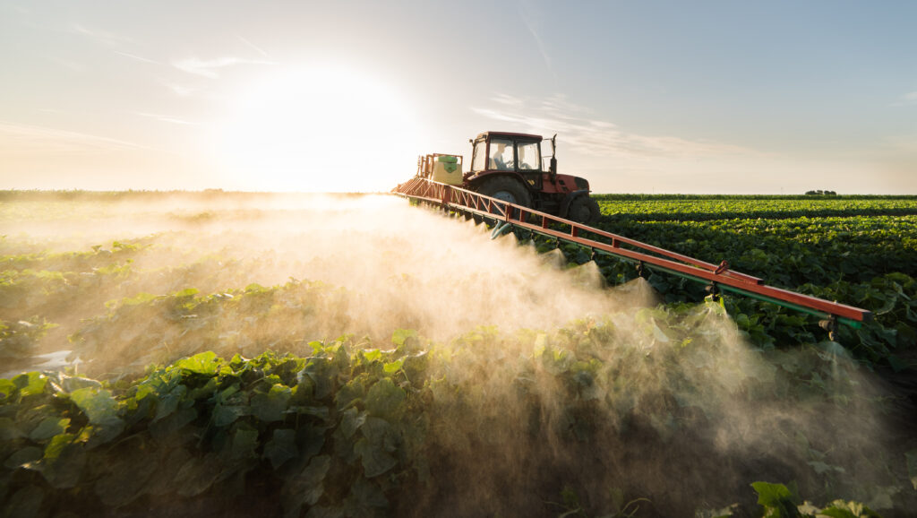Tractor spraying crop protection and nutrients on commercial farm